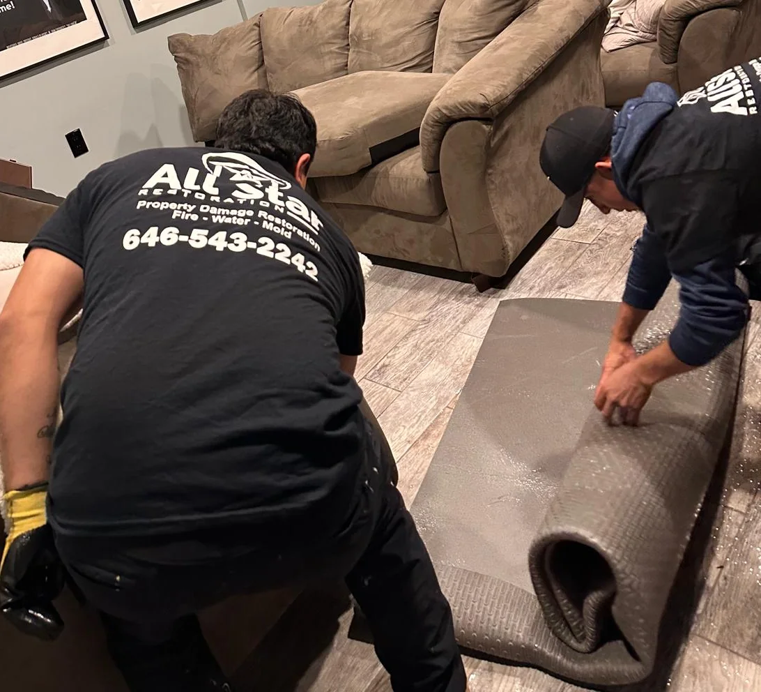 All Star Restoration crew removing wet carpet after water damage in Brooklyn
