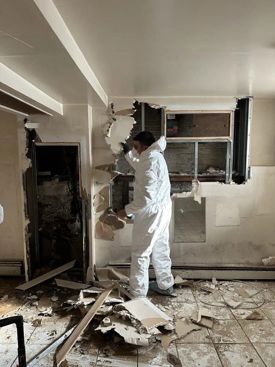 All Star Restoration technician removing water-damaged drywall during restoration
