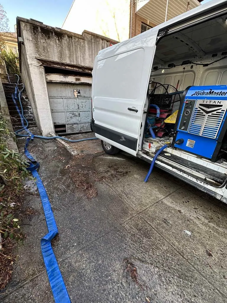 All Star Restoration truck-mounted water extraction unit running hoses into a property in Queens