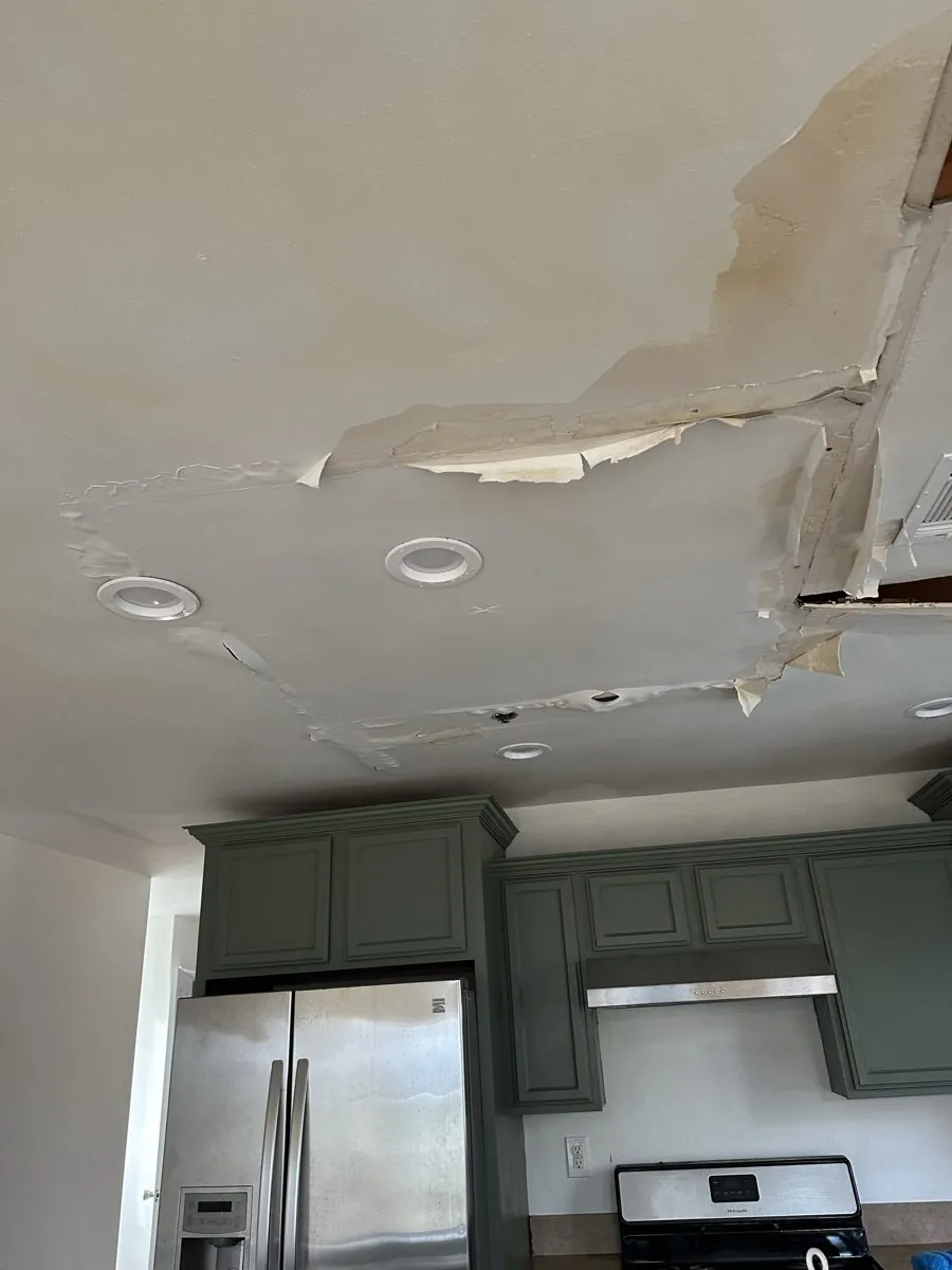 Water-damaged kitchen ceiling with peeling drywall around the recessed lights in Queens